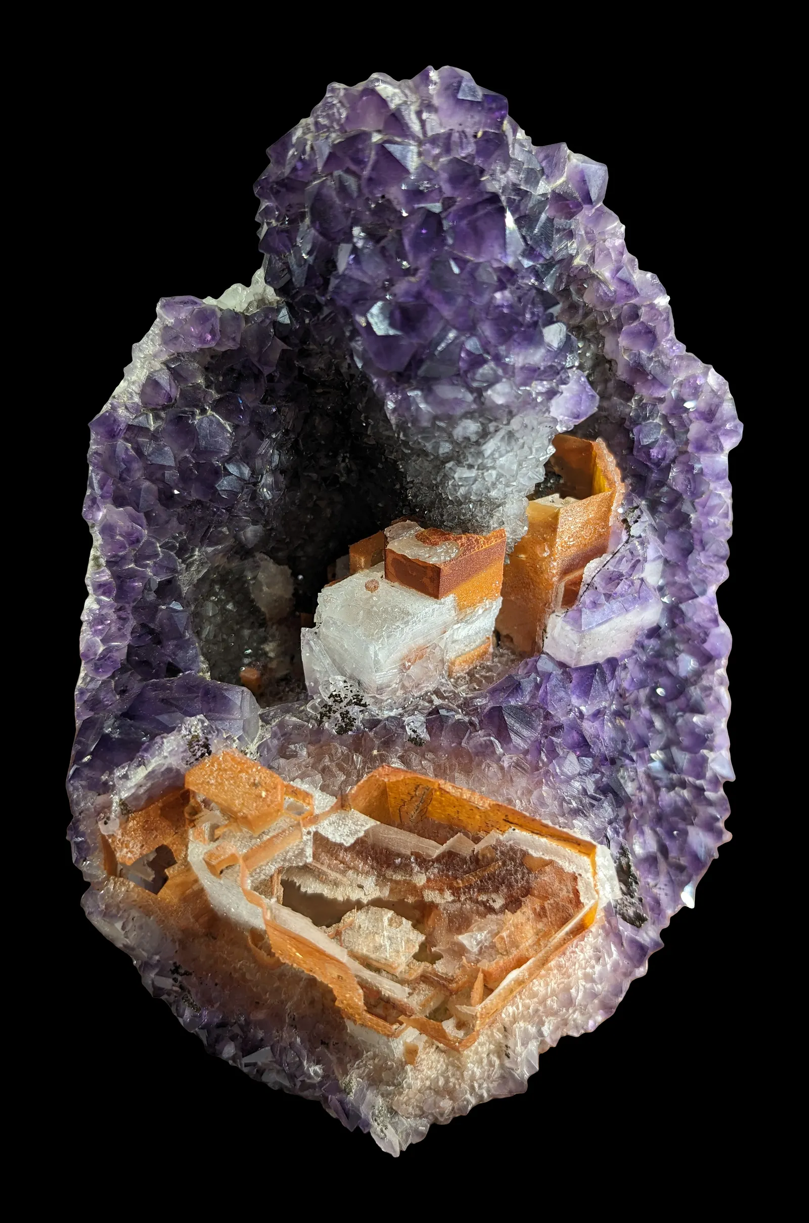 Amethyst geode with calcite crystals, on black